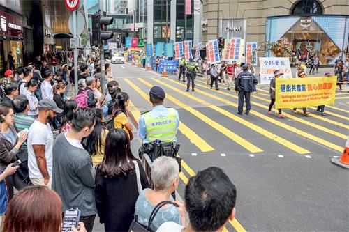 '圖6～14：三月十八日下午二時，香港法輪功學員在香港市中心舉行遊行活動，慶祝並聲援近三億人退出中共黨、團、隊組織，吸引許多香港市民和大陸遊客駐足觀看。'