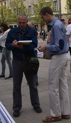 圖9：這位中年烏克蘭遊人（左）含淚簽名，表示支持法輪功
