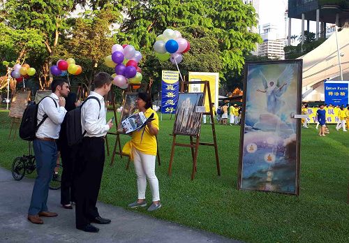 圖3：新加坡芳林公園裏，路人駐足聽法輪功學員講真相