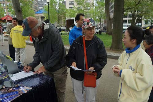 圖4：法輪功學員（右）講真相，遊客在反活摘請願書上簽字