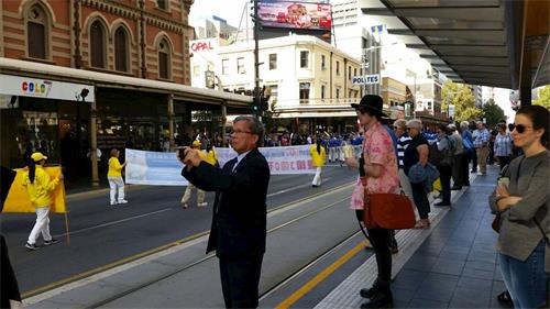 '圖2：南澳首府阿德萊德市中心，民眾駐足觀看聲援三億人三退的遊行隊伍'
