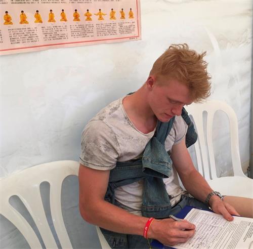 '圖8：學生哈斯穆斯（Rasmus）在反迫害徵簽表上簽名'
