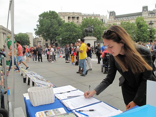 圖7：在倫敦讀碩士研究生的匈牙利女孩馬里亞納﹒菲力維（Mariana Filive ）在特拉法加廣場簽名支持法輪功反迫害。