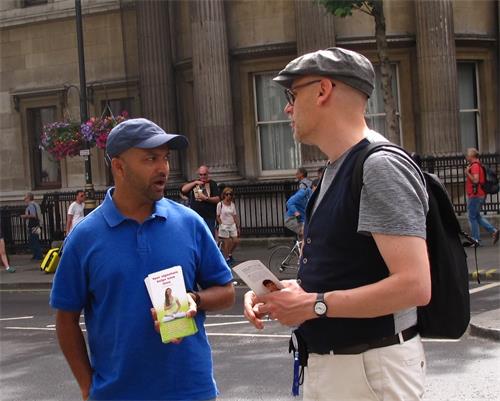 圖9：二零一八年六月二十三日，在倫敦聖馬丁廣場，從比利時安特衛普來倫敦旅遊的保羅（Paul，右）與遇到的法輪功學員交談。
