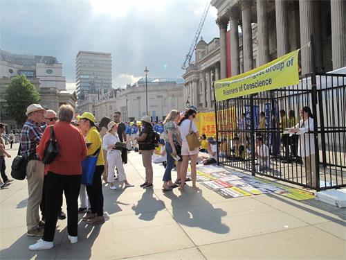 '圖3：二零一八年六月三日下午，英國法輪功學員在倫敦特拉法加廣場北台階廣傳播真相，法輪大法的純正能量吸引廣大民眾踴躍了解真相'