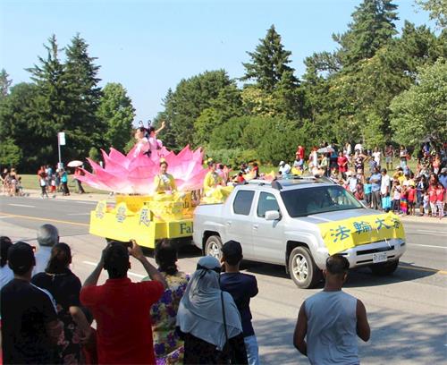 '圖6～7：二零一八年七月一日，多倫多法輪功學員的天國樂團和蓮花花車當天應邀參加下午兩點多倫多市士嘉堡的加拿大國慶遊行。'