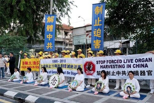 '圖1～2：2018年7月20日，馬來西亞法輪功學員來到中共使館，在車水馬龍的大路旁舉行集會，悼念被中共迫害致死的法輪功學員。'