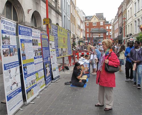 '圖1～2：二零一八年八月十一日，法輪功學員在倫敦唐人街煉功、發真相傳單、徵簽反迫害'