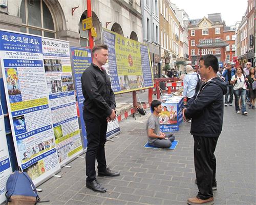 '圖6：二零一八年八月十一日，在倫敦法輪功學員傑克幫助下，一位來自立陶宛的年輕商界人士（左）第一次嘗試法輪功功法，驚呼神奇'