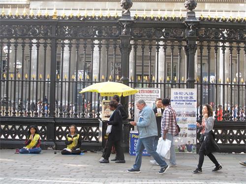 '圖11：二零一八年八月二十五日下午，法輪功學員在大英博物館南門煉功、發真相傳單、講真相勸三退、徵簽反迫害'
