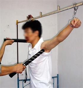 '酷刑演示：穆君奎被北京勞教所警察用七、八根高壓大電棍電擊敏感部位。'