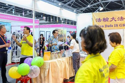 '圖1～3：二零一九年十月十一日至十三日，法輪功學員在新加坡博覽中心（Singapore Expo）舉辦的健康保健展上設立展位，向人們介紹法輪功，並免費教功。'