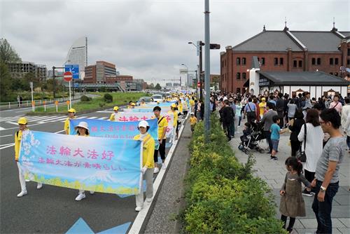 '圖6：法輪功學員的遊行隊伍經過著名景點橫濱紅磚房，遊客紛紛拍照'