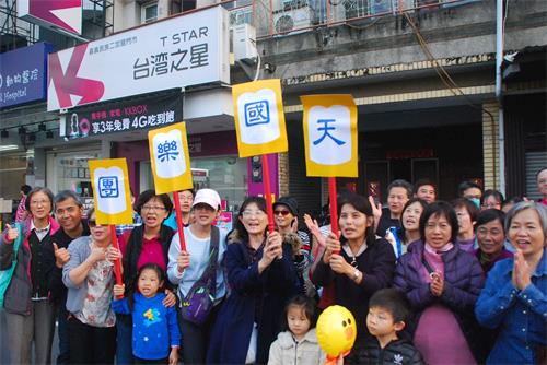 '圖7： 一群嘉義市民在民族路上興奮的舉著寫著「天國樂團」的廣告牌歡迎天國樂團。'
