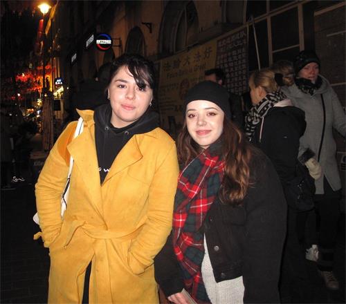 '圖9：二零一九年二月十日晚，在倫敦讀書的法國女士拉奎爾（Raquel， 左）帶著從法國來旅遊的朋友安娜（Anna）在倫敦唐人街簽名支持法輪功反迫害'