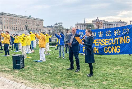'圖1：兩位西人學員用瑞典語、英語向當地民眾及來自世界各地的遊客介紹甚麼是法輪功以及二十年前的四﹒二五，發生在北京的和平理性萬人上訪的事實真相。'