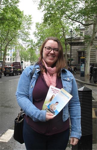 圖10：二零一九年五月十一日，銀行顧問路易絲（Luise）在倫敦市中心遇到慶祝世界法輪大法日的法輪功學員遊行後，站在路邊認真閱讀傳單。