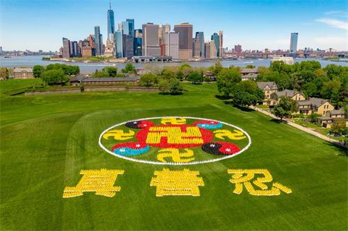'圖1：2019年5月18日，來自全球的部份法輪功學員會聚紐約，在總督島排出「法輪圖形」和「真、善、忍」三字，慶祝世界法輪大法日。'