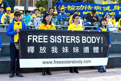 '她的姐姐王易非（右二）手持橫幅抗議'