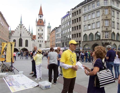 '圖1～2：二零一九年六月十日，法輪功學員在德國慕尼黑瑪琳廣場舉辦活動，揭露中共迫害法輪功。'