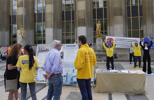'圖1～2：法輪功學員在巴黎人權廣場舉辦活動，介紹功法，並揭露中共對法輪功的迫害。'