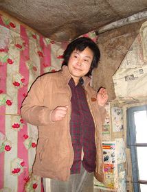 ?�年圖片：被迫害致瘋的柳志梅，當有人試圖接近，她就攥著雙手躲向自家牆角'