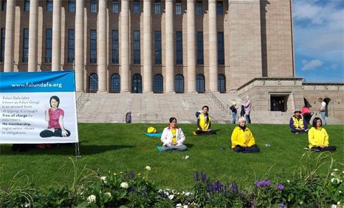 '圖3：芬蘭法輪功學員在國會大廈前集體煉功。'