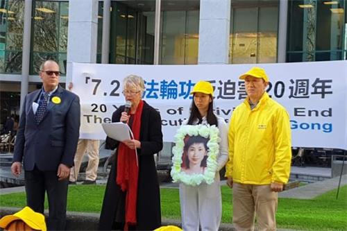 '圖：法輪功學員黃國華（右）和女兒參加集會'