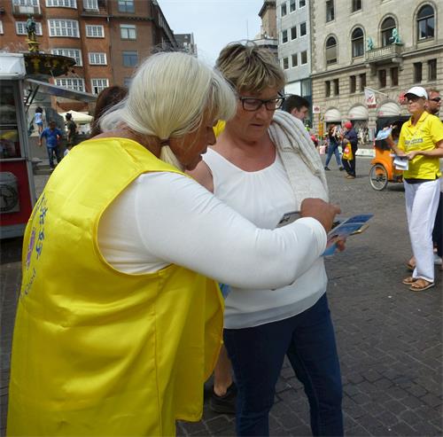 '圖10：丹麥法輪功學員、年屆80的德裔女士卡倫（Karen）在給路人講真相。'
