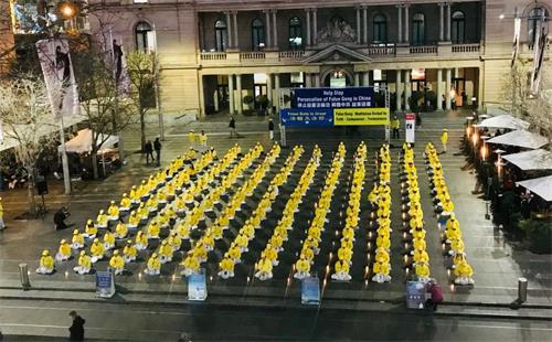 '圖1～2：悉尼法輪功學員在海關大樓前燭光悼念二十年中被中共迫害致死的法輪功學員'