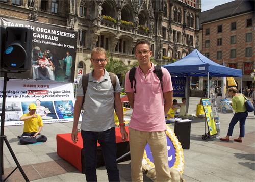 '圖13：社會工作者斯特凡﹒施密德（Stefan Schmider，右）和同伴也主動簽名，制止中共強摘法輪功學員器官。'