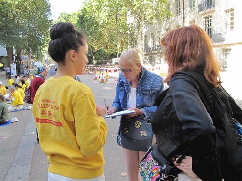 '圖19：西班牙女學員正在向兩位西班牙遊客講真相'