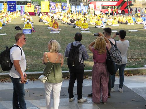 圖1～3：法輪功學員在倫敦議會廣場花園集體大煉功吸引了許多人觀看。