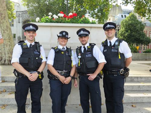 圖4：倫敦警察自豪的將法輪功學員贈送的蓮花掛在警服上