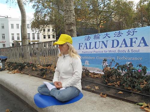 '圖6：二零一九年九月一日，瑞士法輪功學員丹尼絲（Denise）在倫敦萊斯特廣場展示法輪功功法'