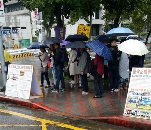 '圖1～2：法輪功學員常年堅持在台北國父紀念館擺展板，講真相，風雨無阻，幫助很多遊客了解了法輪功真相。'