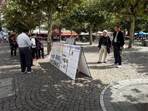'圖5～6：中國遊客在保羅廣場觀看法輪功真相展板'