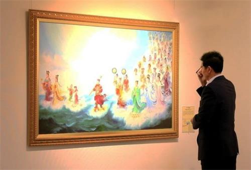 '圖2：釜山市民會館的安賢根（音譯）館長在認真欣賞畫作'