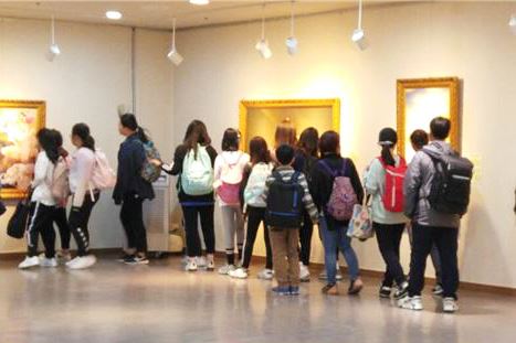 '圖5：小學生們在冰上中心展館的美術展上團體觀看'