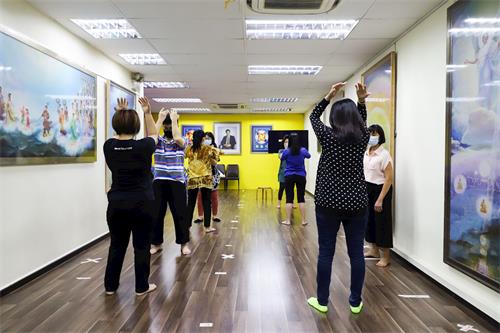 '圖1：華語班的新學員學習法輪功功法動作。'