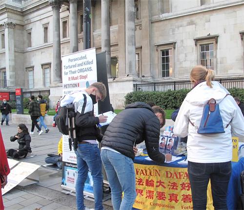 '圖1～8：二零二零年十月十日，英國法輪功學員繼續在倫敦特拉法加廣場北平台舉行講真相反迫害活動，吸引過往民眾關注支持、簽名反迫害'