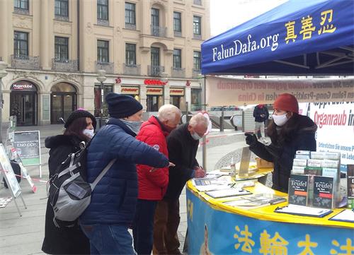 '圖1：法輪功學員於二零二零年十二月十九日，在德國慕尼黑市中心卡爾斯廣場（Karlsplatz）舉辦信息日活動。圖為慕尼黑民眾簽名聲援法輪功學員反迫害。'