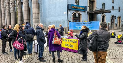 '圖4：法輪功學員在斯德哥爾摩市音樂廳（Konserthuset）旁，舉辦講真相、徵簽反迫害活動。'