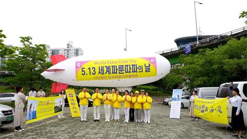 '圖1：二零二零年五月十日，為慶祝世界法輪大法日，部份法輪功學員在首爾漢江公園上空放飛艦形飛行器。'