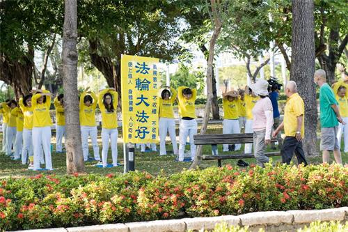 '圖3：高雄部份學員在小港高雄公園展示祥和優美的五套功法，吸引不少散步的民眾駐足觀看，了解真相。'
