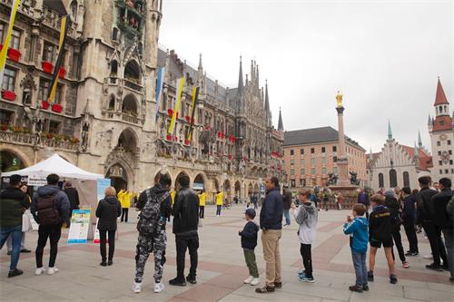 '圖1：二零二零年六月十日，德國慕尼黑瑪琳廣場（Marienplatz）上，民眾觀看法輪功學員展示功法演示。'