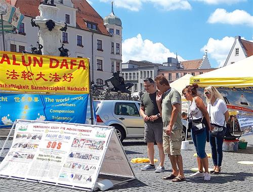 '圖1：二零二零年七月十八日，法輪功學員在德國奧格斯堡（Augsburg）的市政廳廣場（Rathausplatz）舉辦信息日活動，吸引了德國民眾的關注。'