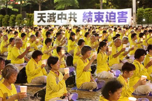 法輪功學員在台北市政府廣場前舉辦反迫害21週年燭光悼念活動。