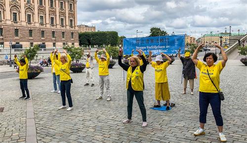 '圖1：法輪功學員在斯德哥爾摩市中心國會大廈旁的錢幣廣場，舉辦講真相活動，揭露中共對法輪功長達二十一年的殘酷迫害。'