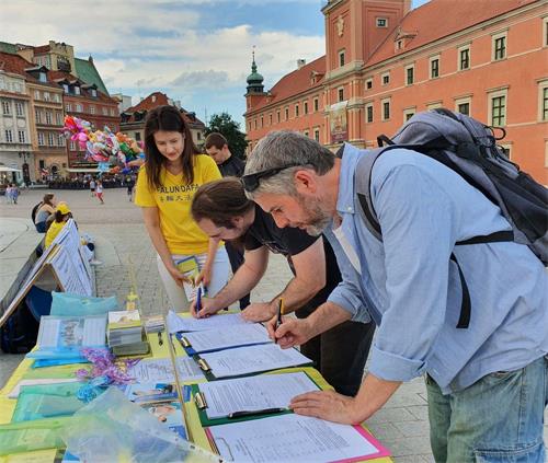 '圖5～8：波蘭法輪功學員在華沙古城舉辦講真相活動 民眾簽名支持法輪功'